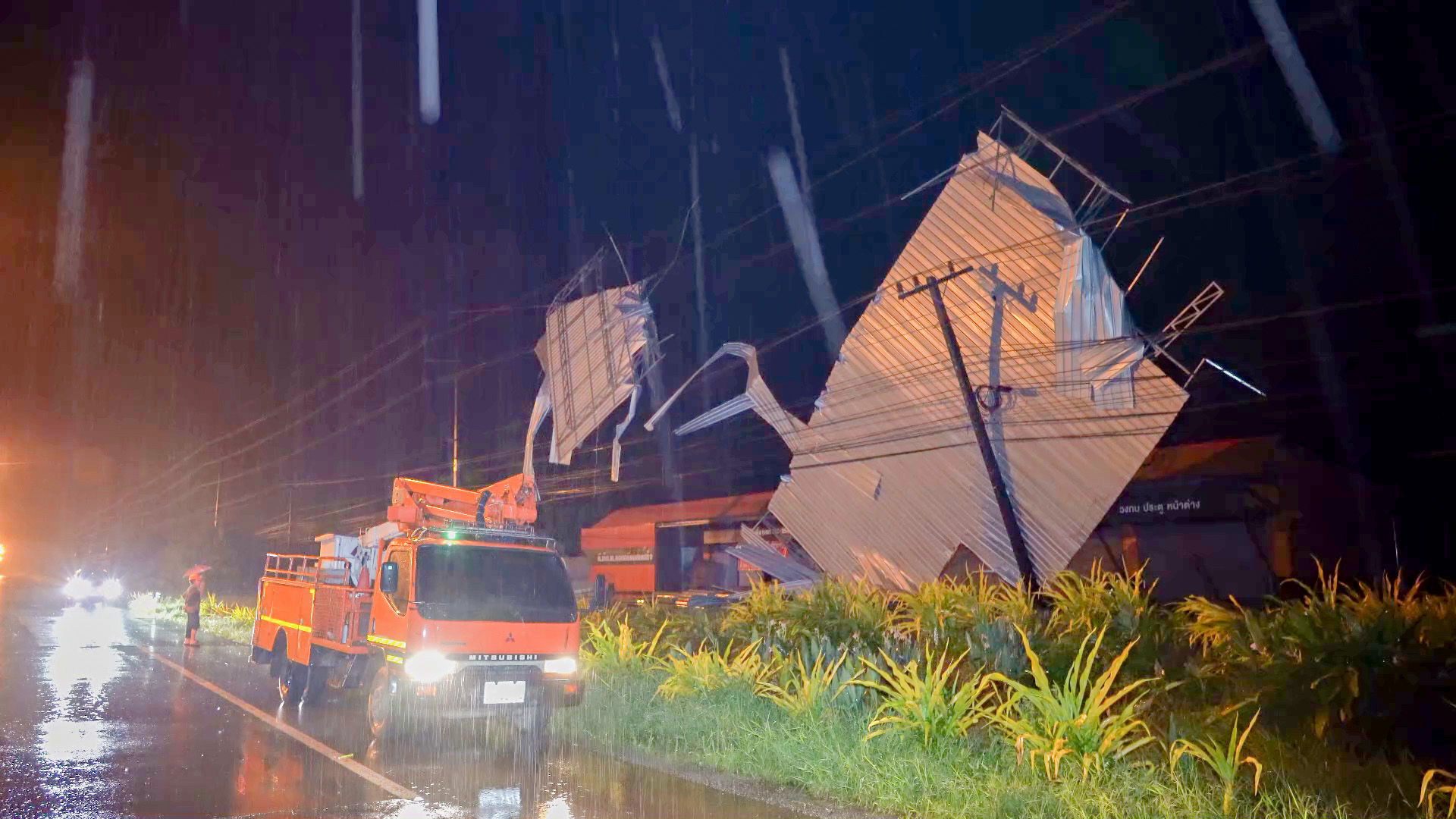 พายุฝนพัดถล่ม หลังคาเมทัลชีท ปลิวพาดสายไฟฟ้าแรงสูงทำไฟดับทั้งเมือง