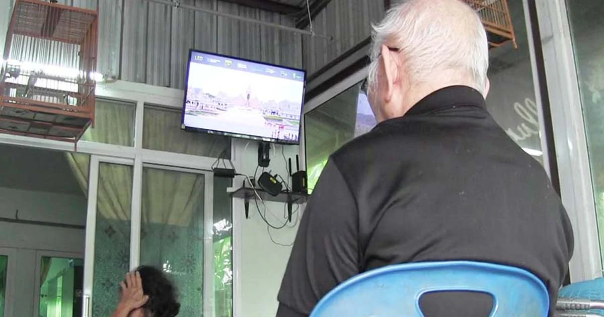 ตายายดูถวายดอกไม้จันทน์ผ่านทีวี ด้วยความอาลัยรักในหลวง ร.9